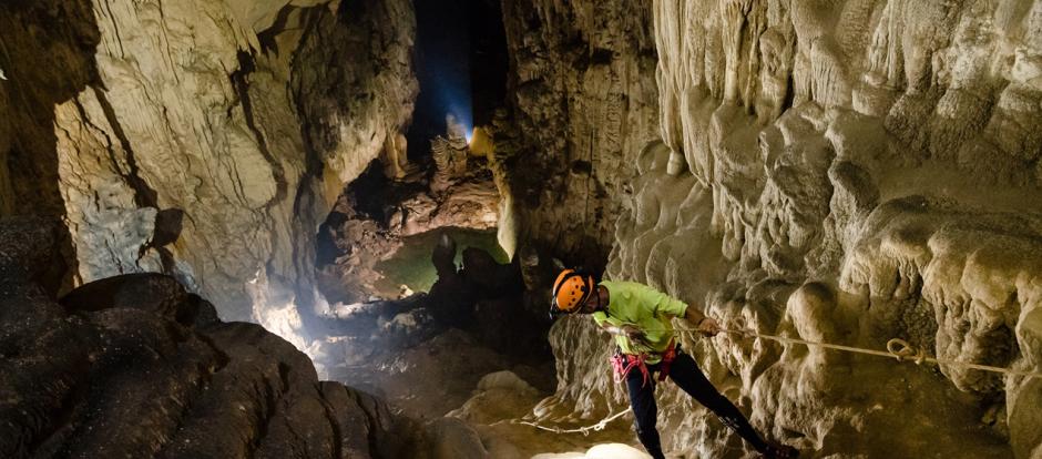 Espeleólogo bajando al interior de la cueva.