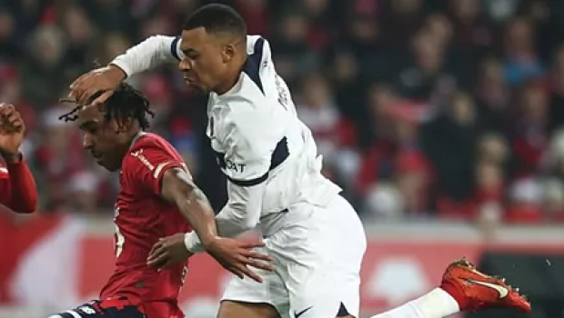 El defensa del Lille, Leny Yoro, conteniendo a Mbappé