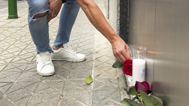 Un aficionado bético coloca una vela y una rosa hoy domingo en el domicilio y sede social de una de las empresas de Manuel Ruiz de Lopera en la calle Jabugo de Sevilla. EFE/ David Arjona