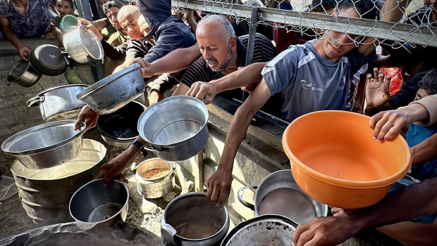 Imagen de archivo de palestinos esperando en largas filas para recibir víveres distribuidos por organizaciones benéficas