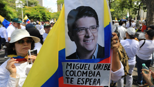 Una foto del senador Miguel Uribe Turbay sobre la bandera colombiana durante la Marcha del silencio