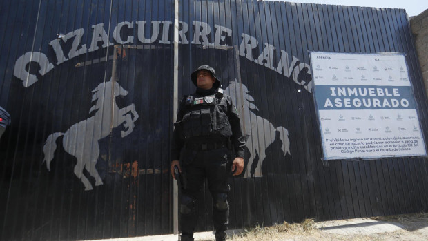 Fotografía de archivo del 20 de marzo de 2025 de un integrante de la fiscalía estatal resguardando la entrada al Rancho Izaguirre en el municipio de Teuchitlán, Jalisco (México). Los diez detenidos en septiembre de 2024 en el rancho Izaguirre, vinculado con un cartel del narcotráfico en el municipio de Teuchitlán, estado de Jalisco