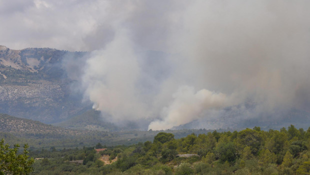 Un helicóptero trabaja en las tareas de extinción del incendio forestal de alta intensidad que se inició ayer en Paüls (Tarragona)