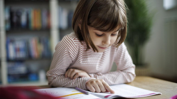 Niña leyendo un libro en una clase