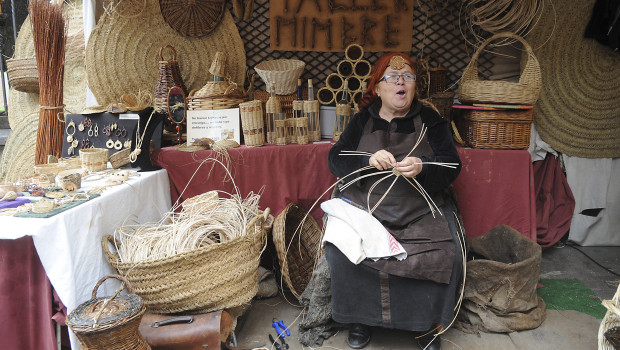 Una mujer fabrica diversos objetos de mimbre en un Mercado Medieval, en una imagen de archivo