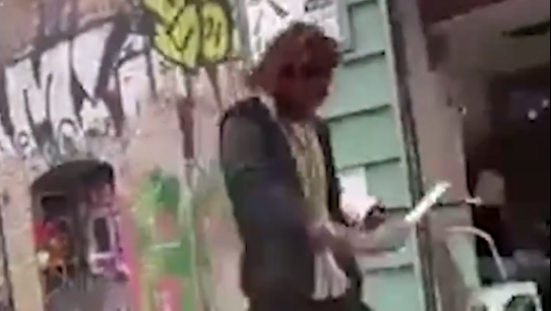 Un hombre se pasea por el barrio de El Raval mientras afila un cuchillo