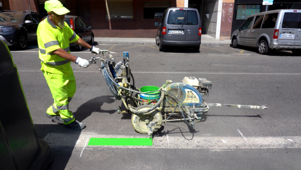 Un operario pinta las zonas de estacionamiento regulado en Usera