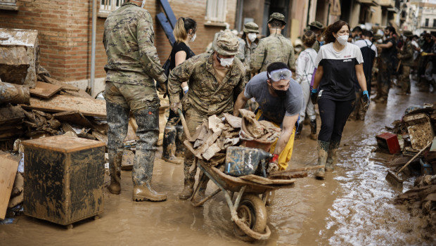 Fotografía que acompaña al Rey y en la que se ven a vecinos, voluntarios y miembros de Fuerzas Armadas, tras la dana