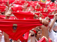 Los pañuelos rojos elevados tradicionales de San Fermín durante el Chupinazo