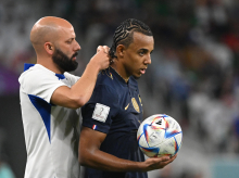 Un miembro del staff técnico de Francia retira la cadena con la que ha jugado Koundé 42 minutos