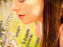 Una mujer huele flores aromáticas