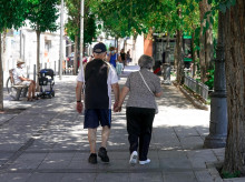 Una pareja de ancianos camina por la calle cogida de la mano.