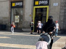 Una mujer camina por la plaza Sant Jaume de Barcelona con un velo integral