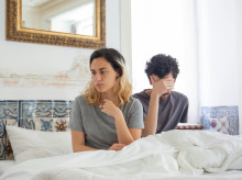Una pareja en la cama tras una discusión