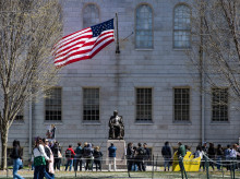 Manifestantes con pancartas se congregaron alrededor de la estatua de John Harvard en Harvard Yard tras una protesta contra los ataques del presidente Donald Trump a la Universidad