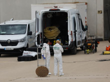Dos agentes de Criminalística de la Guardia Civil dentro de la parcela de la nave, junto a la fosa séptica