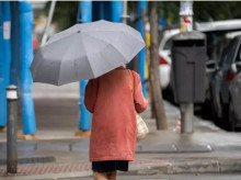 Una mujer pasea por una calle con un paraguas