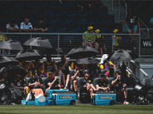 Los futbolistas del Borussia Dortmund se protegen del sol en el banquillo