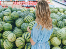 Una mujer mirando sandías en el supermercado