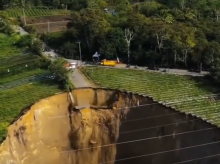 Los vehículos junto a parte del socavón en lo que queda de carretera