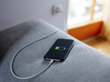 Carga de un teléfono móvil, enchufado en la toma de corriente