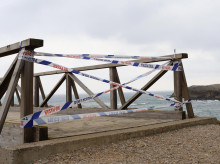 Precinto policial para impedir el paso en la pasarela de la senda costera de Cabo Mayor a la playa de La Maruca, en Santander