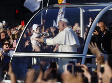 El papa León XIV hace alguna parada para acercarse a varios bebés en su recorrido por Madrid en el papamóvil para dirigirse a la Plaza de Lima