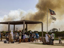 Imagen tomada este jueves de Varias personas desalojan la playa durante un incendio forestal en El Saler, junto a la Albufera de Valencia
