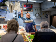 Varias personas hacen compras en una pescadería.