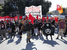 Una manifestación en Barcelona en defensa de la vivienda en la que se muestran banderas rojas