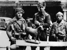 Dos soldados y un joven sargento, en el centro de la imagen, del Ejército de Galicia se fotografían junto al Torico