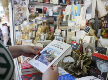 Una lectora examina un libro en la Feria del Libro de Madrid