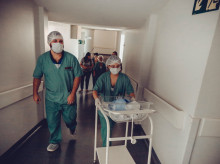 Una matrona llevando a un bebé recién nacido por un hospital