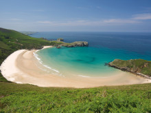 Playa de Torimbia, Asturias. Esta playa ubicada en la localidad asturiana de Niembro en Llanes, es considerada paisaje protegido desde el punto de vista medioambiental por su vegetación. Es considerada como uno de los mejores arenales naturistas. Para acceder a esta playa, hay que atravesar Niembro y hacer los últimos dos kilómetros del trayecto a través de un estrecho camino de arena. Además, cuando la marea está baja desde Torimbia se puede acceder a otras playas, como la de Portacos y Peñadrada. Asimismo, la anchura de Torimbia varía dependiendo de la marea, por lo que oscila entre los 76 y 100 metros. Torimbia, es una playa de concha encajada, y es este aislamiento natural lo que la hace perfecta para el nudismo. Muchos aficionados utilizan esta playa para esta práctica. La profundidad de la zona de baño es bastante baja, no excede el metro y medio, además de esto, la corriente es escasa, por lo que no es una playa peligrosa.