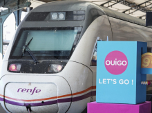 Un tren de Renfe pasa junto a un cartel publicitario de Ouigo, esta mañana en Valladolid