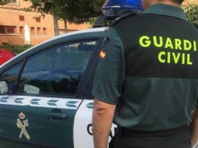 Imagen de archivo de un agente de la Guardia Civil ante un coche patrulla