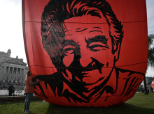 Una mujer abraza una enorme pancarta con la imagen del expresidente uruguayo José "Pepe" Mujica, colgada frente al Palacio Legislativo