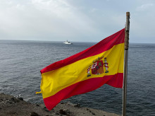 La bandera de España ondea en la isla de Alborán; al fondo, el buque de acción marítima Furor de la Armada española