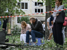 Residentes reaccionan mientras los rescatistas ucranianos realizan labores de búsqueda y rescate en un edificio residencial gravemente dañado tras el ataque con misiles rusos en Kiev