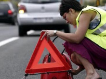 Una conductor coloca los triángulos de emergencia con el chaleco puesto