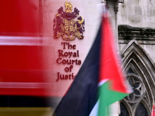 Una bandera palestina es ondeada por un manifestante afuera de los Tribunales Reales de Justicia, el Tribunal Superior de Gran Bretaña, en Londres