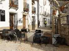 GRAZALEMA (CÁDIZ), 16/02/2026.- Sillas y mesas apiladas en una calle de Grazalema este lunes. Un primer grupo de vecinos desalojados hace 11 días por el temporal en Grazalema (Cádiz) ha podido volver a sus hogares a partir de las 16:05 horas de este lunes, cuando la Guardia Civil ha permitido el acceso a una treintena de vehículos al municipio. EFE/ Jorge Zapata