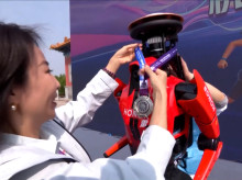 El robot ganador de la maratón de Pekín, de la empresa Honor, recibe su medalla