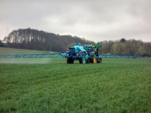 Un tractor aplica fertilizantes sobre la tierra