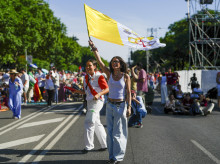 Una joven porta una bandera de El Vaticano en los alrededores de la Plaza de Lima. En el fondo una voluntaria