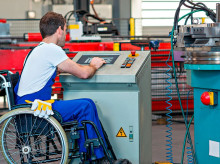 Persona en silla de ruedas trabajando en una fábrica