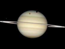 Imagen del 24 de febrero de 2009, cuando los anillos de Saturno estaban casi de canto, el Hubble rastreó cuatro de sus lunas mientras cruzaban la superficie del gigantesco planeta anillado.