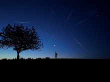 Silueta de un hombre y campo bajo las estrellas y la luz de la luna