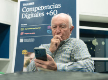 Un señor practica con el móvil durante los talleres Competencias Digitales +60