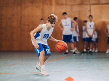 Un adolescente practicando baloncesto junto a sus compañeros de equipo